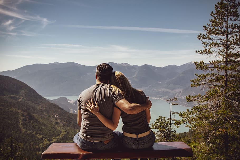 pareja en banco con nubes
